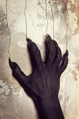 Black hands of the devil on wall background