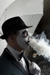 Evil clown wearing a bowler hat vaping