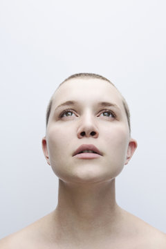 Caucasian woman with shaved-head looking up