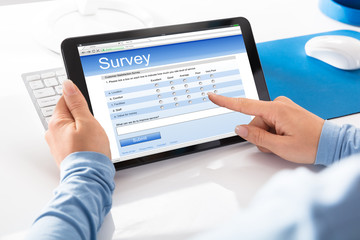 Woman Holding Digital Tablet With An Online Survey Form