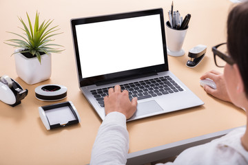 Businesswoman Using Laptop At Office Desk
