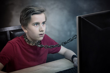 Teenager chained to his computer. Addiction concept.