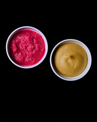 Horseradish and mustard on a black background.Sauces for food.. Top view.
