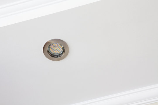 Ceiling moldings on a white surface with LED lamp.