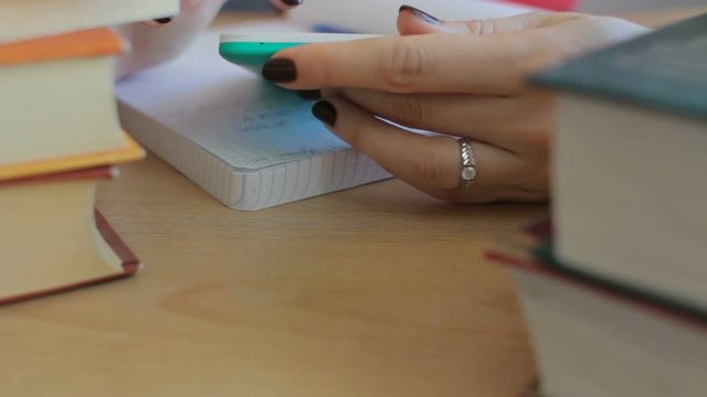 Close up of student using smartphone doing homework. Education, technology, exam