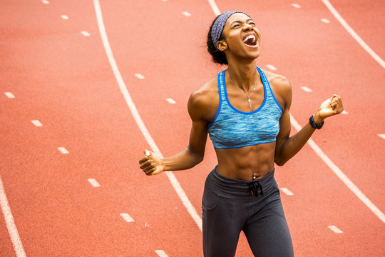 Happy Black athlete celebrating on track