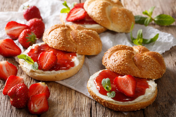 Buns with strawberry jam, fresh berries, cream cheese and mint closeup. horizontal