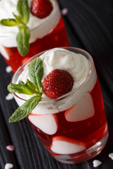 Festive strawberry jelly with whipped cream and mint closeup vertical