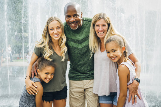 Portrait of smiling family standing against fountain