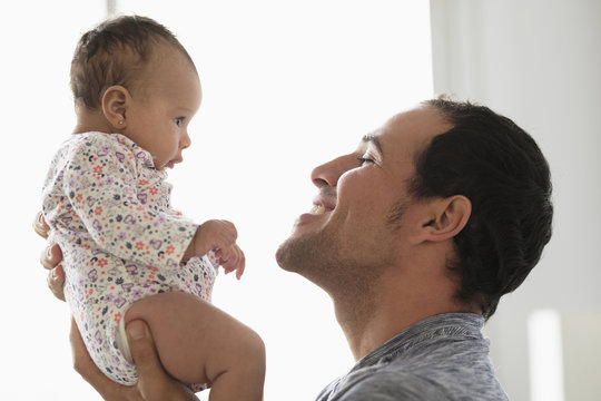 Hispanic Father Lifting Baby Daughter