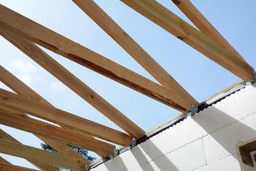 The wooden structure of the building. Wooden frame building. Wooden roof construction.  house building. Installation of wooden beams at construction the roof truss system of the house.