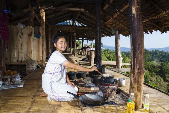 Smiling Asian woman cooking on patio outdoors