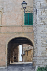 An old street lamp and a closed shutter above the archway to Villa a Sesta in Chianti - Tuscany, Italy