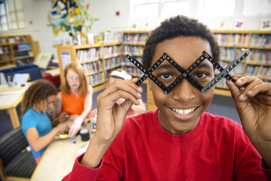Boy playing with plastic blocks in library