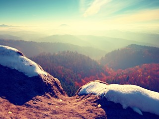 Rocky peak above inverse mist. Winter cold weather in mountains, colorful fog. Misty valley