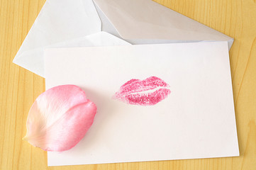 Romantic card with lips imprint and pink rose petal