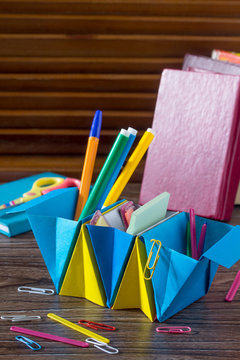 A children's office organizer made of paper is filled with office accessories. Handmade. The project of children's creativity, handicraft origami, crafts for children.