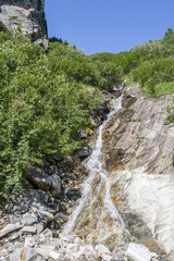 Fototapeta na wymiar Clear mountain stream and waterfall