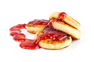 Fried cottage cheese fritters or pancakes with strawberry jam isolated on white background