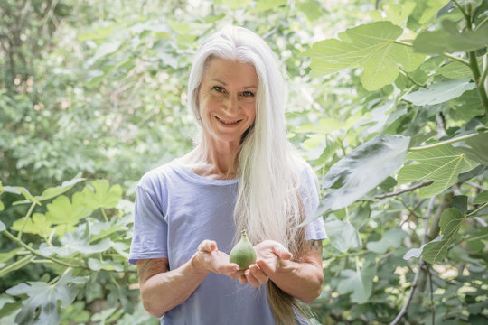 Caucasian woman holding fruit in garden