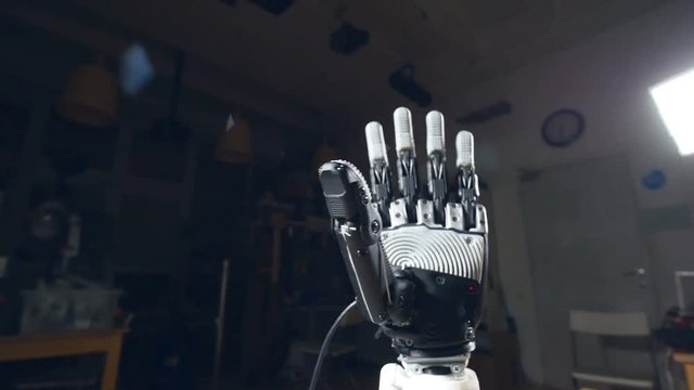 The camera is moving in slow motion around the robot hand, close up.