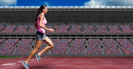 Sportswoman running on tracks against buildings