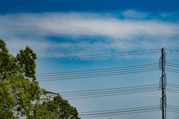 blue sky on sunny day with high voltage electric power supply pole