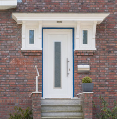 Haustür eines Hauses in weiß mit blauen Rahmen