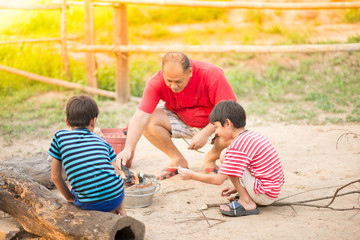 Asain Father and son making barbecue togheter outdoor activity