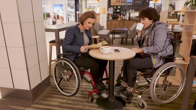 Two physically challenged women in a cafe