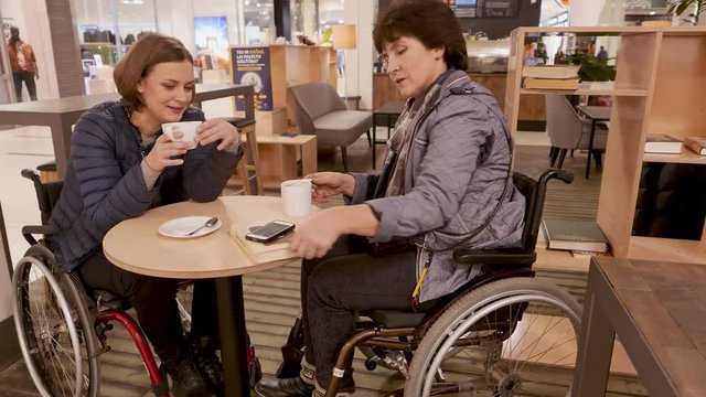 Two physically challenged women in a cafe