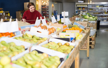 Portrait of  young customer selecting apple in grocery