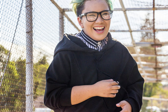 Androgynous Asian woman laughing on footbridge