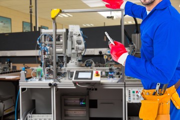Midsection of handyman standing by machine