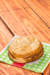 Round puff pastry with sesame on the napkin over wooden background