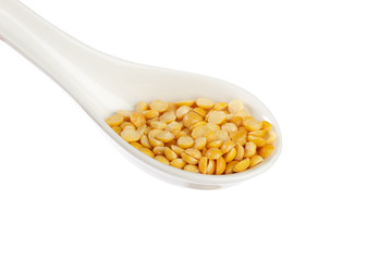 Dry yellow split peas isolated on white.