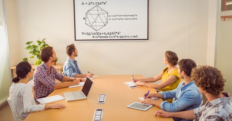 Business people looking at diagram on screen in conference room