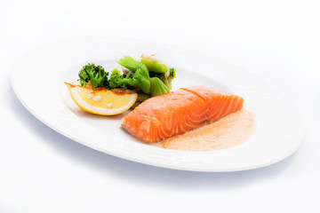 cooked salmon with a side dish of broccoli and Lemon