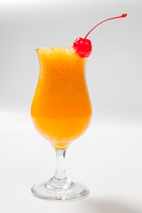 orange cocktail decorated with cherry on white background
