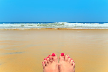 Woman legs on the beach.