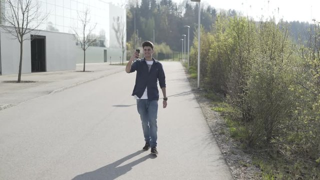Junger Mann telefoniert mit Smartphone Videotelefonie