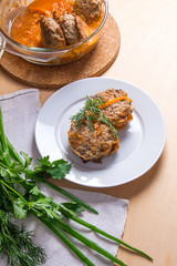 Rissole of pork served on a white plate and herbs - dill, green onion, parsley around the plate.