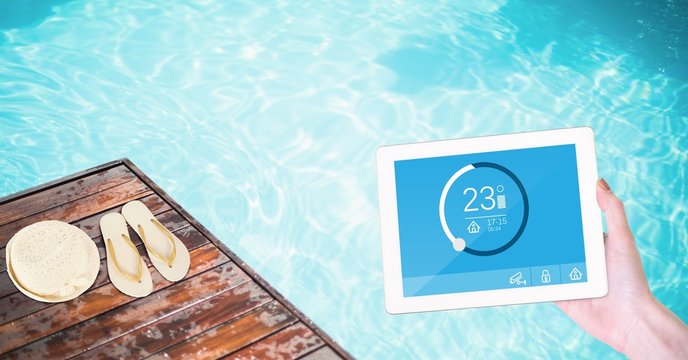 Woman using smart home app on tablet computer by swimming pool