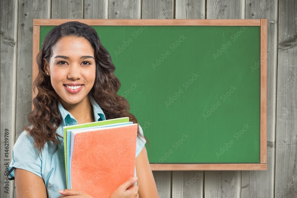 Poster Female student holding book against chalkboard