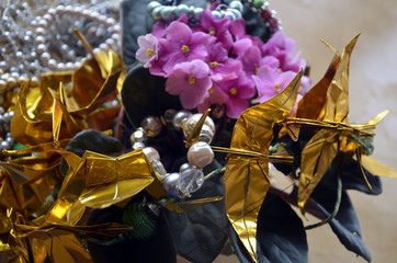 Bouquet de gloxinias roses orné de bijoux en perles et de grues dorées origami