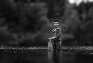 young little boy catches fish in the lake
