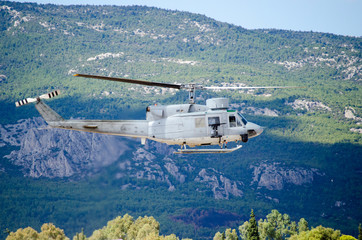 Helicopter bell uh 1. Exhaust gases,
machine gun mountain background.