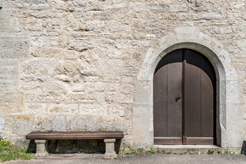 Altes Gemäuer mit Holztüre und Holzbank