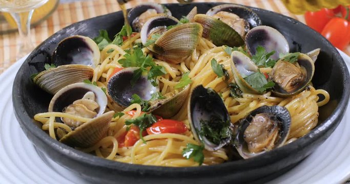 Pouring olive oil over delicious spaghetti alle vongole (clams)