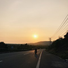 мужчина на мотоцикле едет в закат 